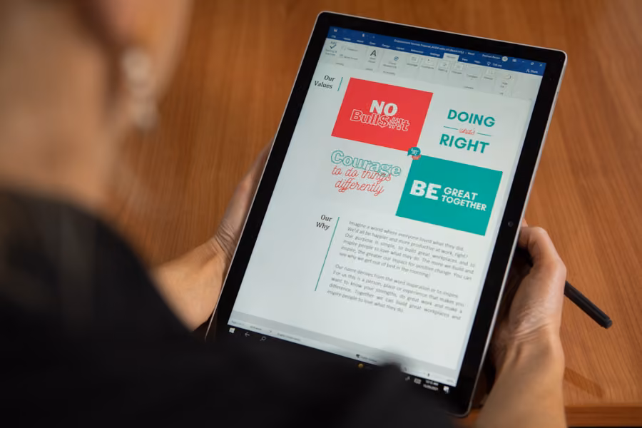 An out of focus woman is looking at an iPad which displays the Inspire HQ Values and Why.